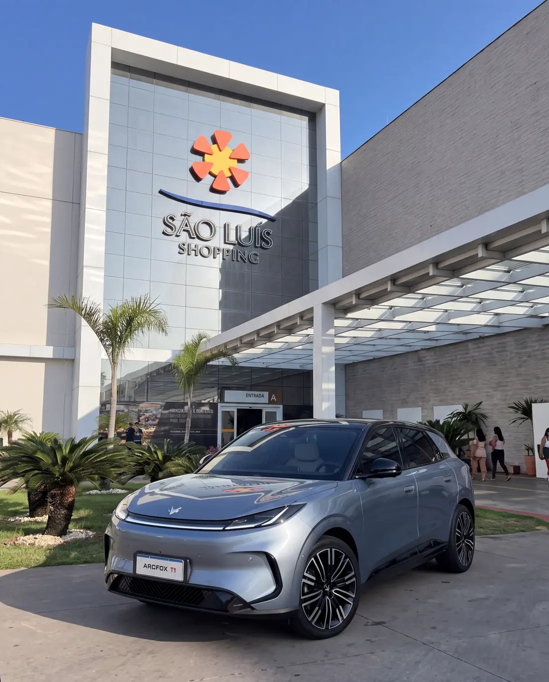 Arcfox T1 cinza estacionado em frente à entrada do São Luís Shopping, sob o céu azul
